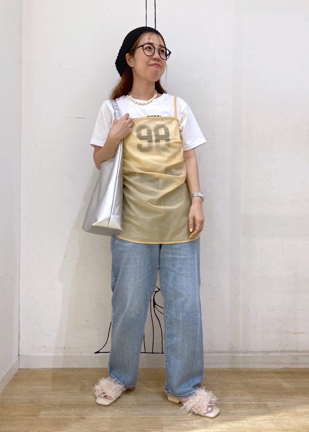 ホワイト系のTシャツ/カットソー、ベージュ系のサンダル、オレンジ系のベストを着用したレディースの夏コーディネートの2枚目の写真