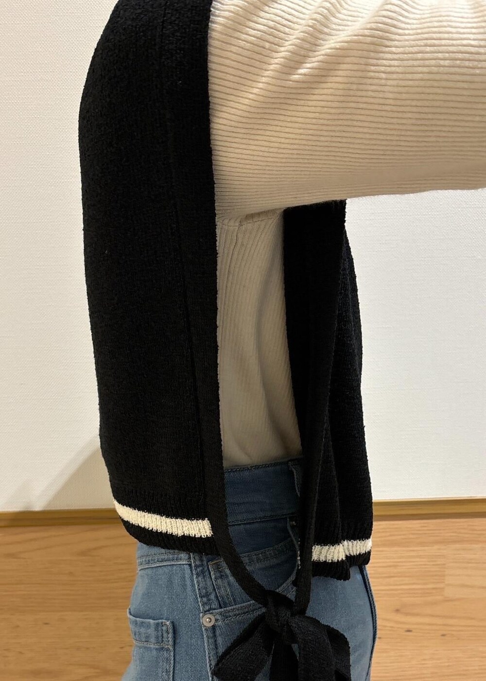 ホワイト系のニット/セーター、ブラック系のローファー、ブラック系のベストを着用したレディースの冬コーディネートの3枚目の写真