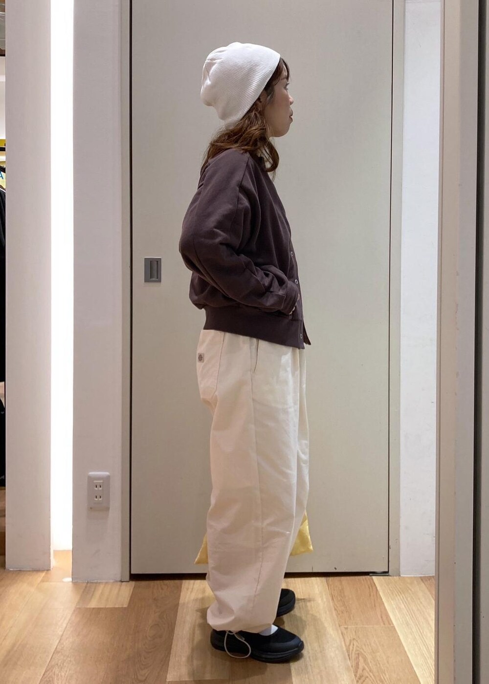 ブラック系のスニーカー、ホワイト系のその他パンツ、ブラウン系のカーディガン/ボレロを着用したレディースの秋コーディネートの2枚目の写真