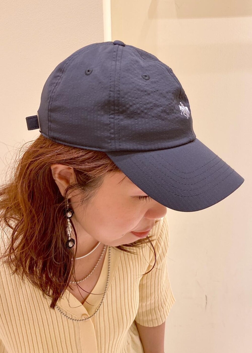 ブルー系のデニムパンツ、ブラック系のトートバッグ、ベージュ系のカーディガン/ボレロを着用したレディースの夏コーディネートの9枚目の写真