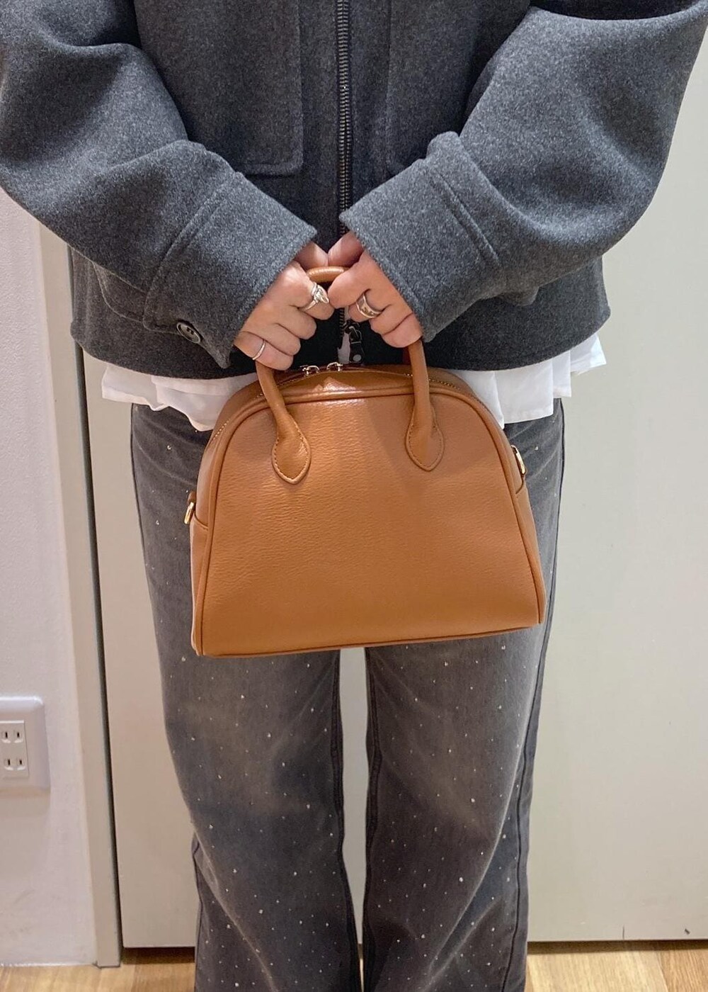 グレー系のブルゾン、グレー系のニット/セーター、ホワイト系のTシャツ/カットソーを着用したレディースの秋コーディネートの9枚目の写真