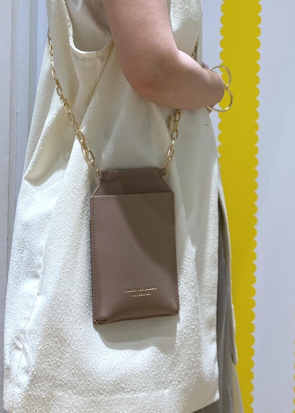 ホワイト系のサンダル、ベージュ系のショルダーバッグ、ホワイト系のベストを着用したレディースの春コーディネートの5枚目の写真