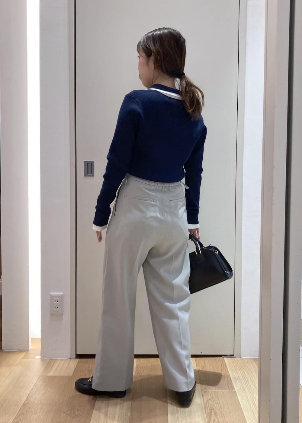 ブラック系のローファー、ブラック系のボストンバッグ、グリーン系のその他パンツを着用したレディースの冬コーディネートの3枚目の写真