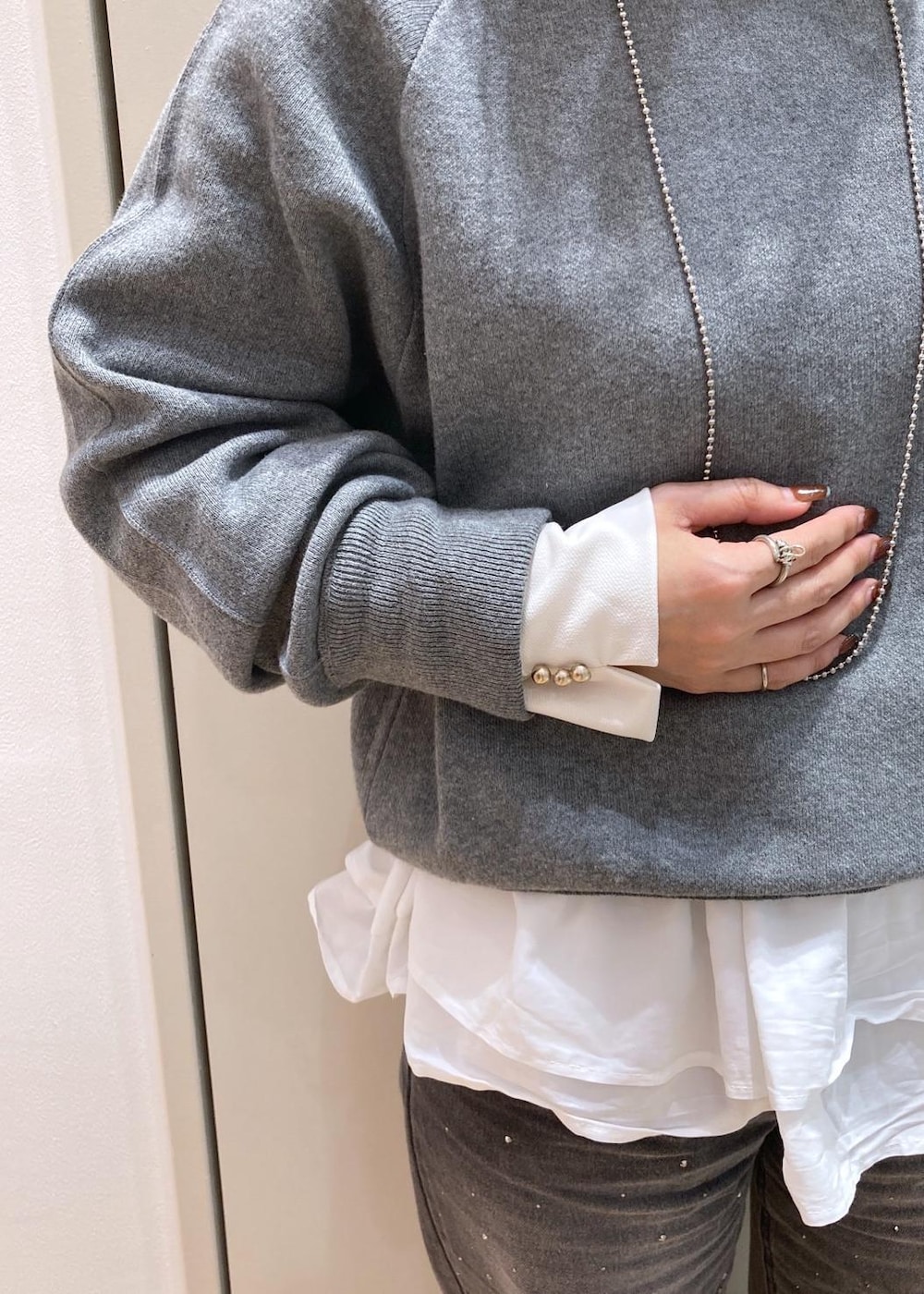 グレー系のブルゾン、グレー系のニット/セーター、ホワイト系のTシャツ/カットソーを着用したレディースの秋コーディネートの6枚目の写真