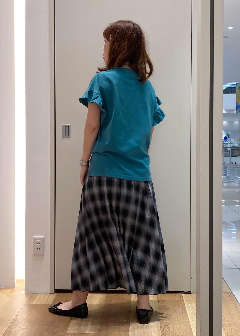 ブラック系のハンドバッグ、ブラック系のバレエシューズ、グリーン系のTシャツ/カットソーを着用したレディースの夏コーディネートの3枚目の写真