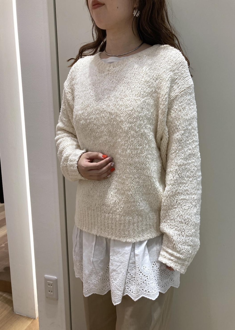 ベージュ系のチノパンツ、イエロー系のトートバッグ、ホワイト系のニット/セーターを着用したレディースの春コーディネートの6枚目の写真