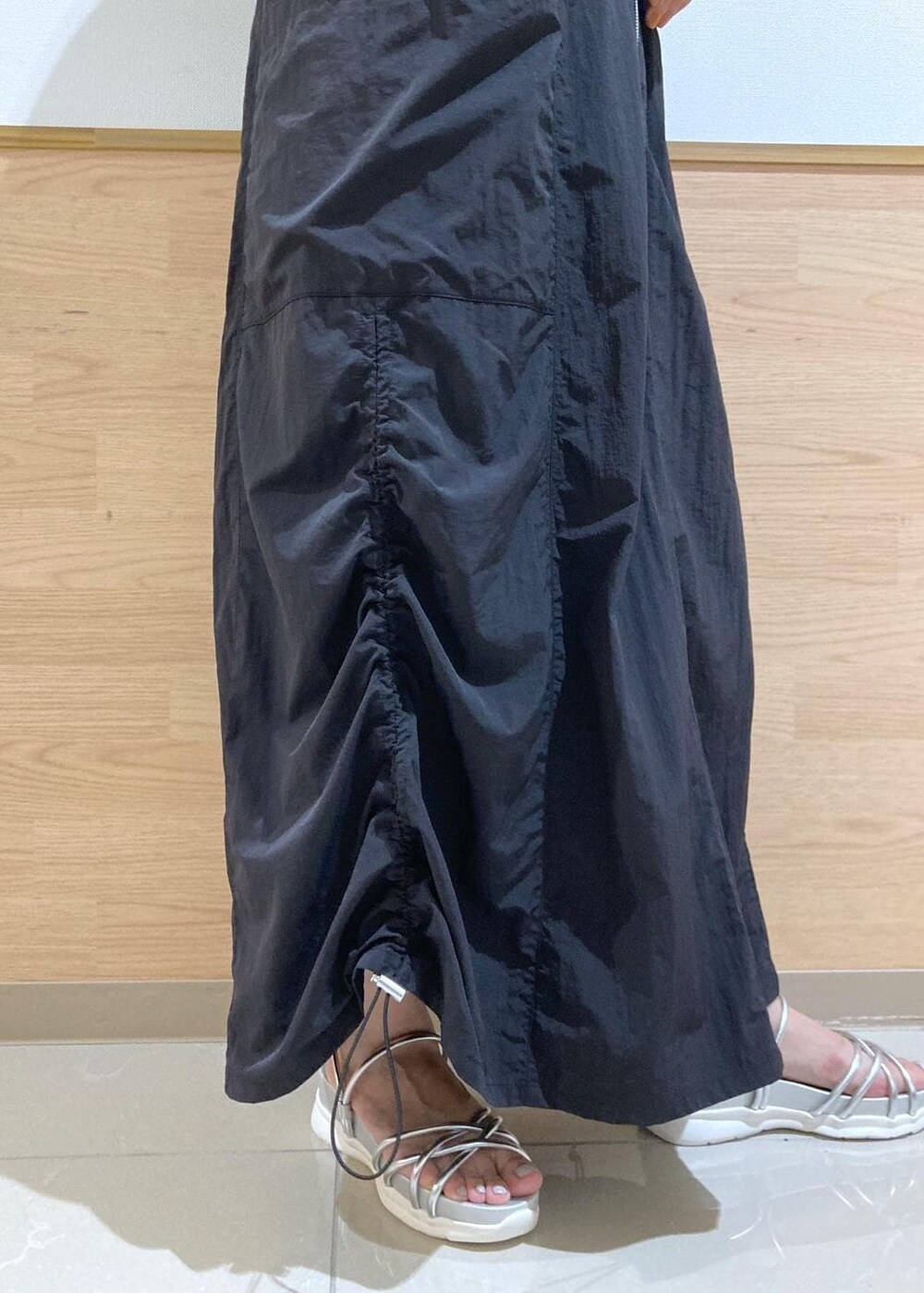 シルバー系のサンダル、ブラック系のワンピース、シルバー系のトートバッグを着用したレディースの夏コーディネートの6枚目の写真