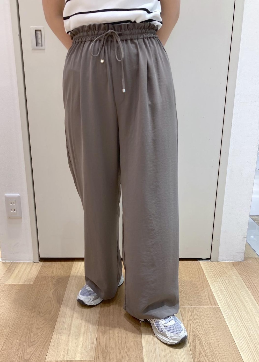 ホワイト系のトートバッグ、ホワイト系のニット/セーター、ベージュ系のTシャツ/カットソーを着用したレディースの夏コーディネートの5枚目の写真