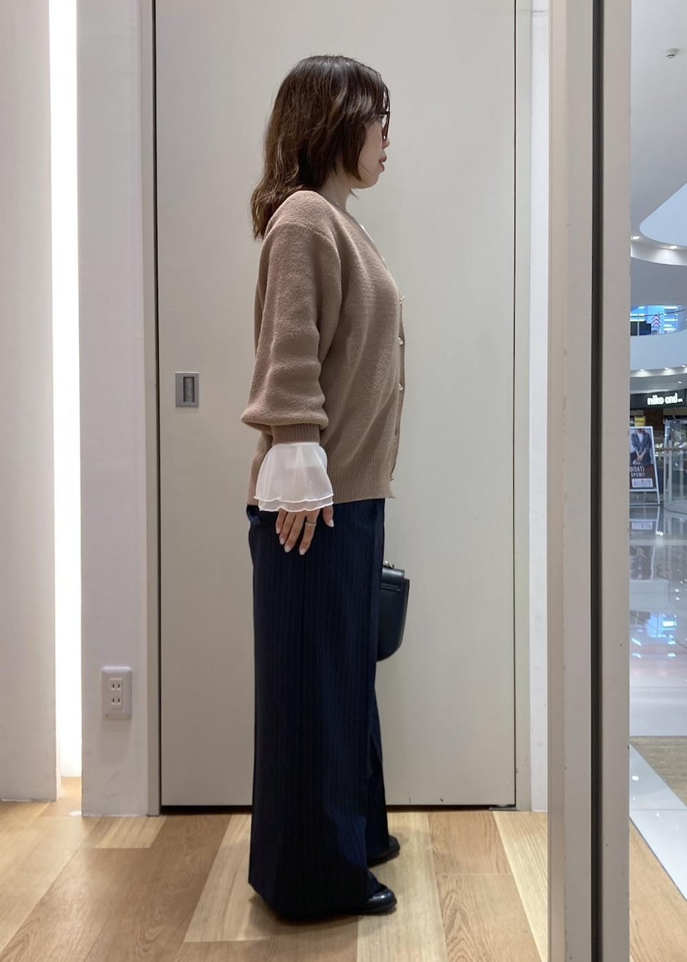 ベージュ系のカーディガン/ボレロ、ホワイト系のTシャツ/カットソー、ブルー系のその他パンツを着用したレディースの冬コーディネートの2枚目の写真