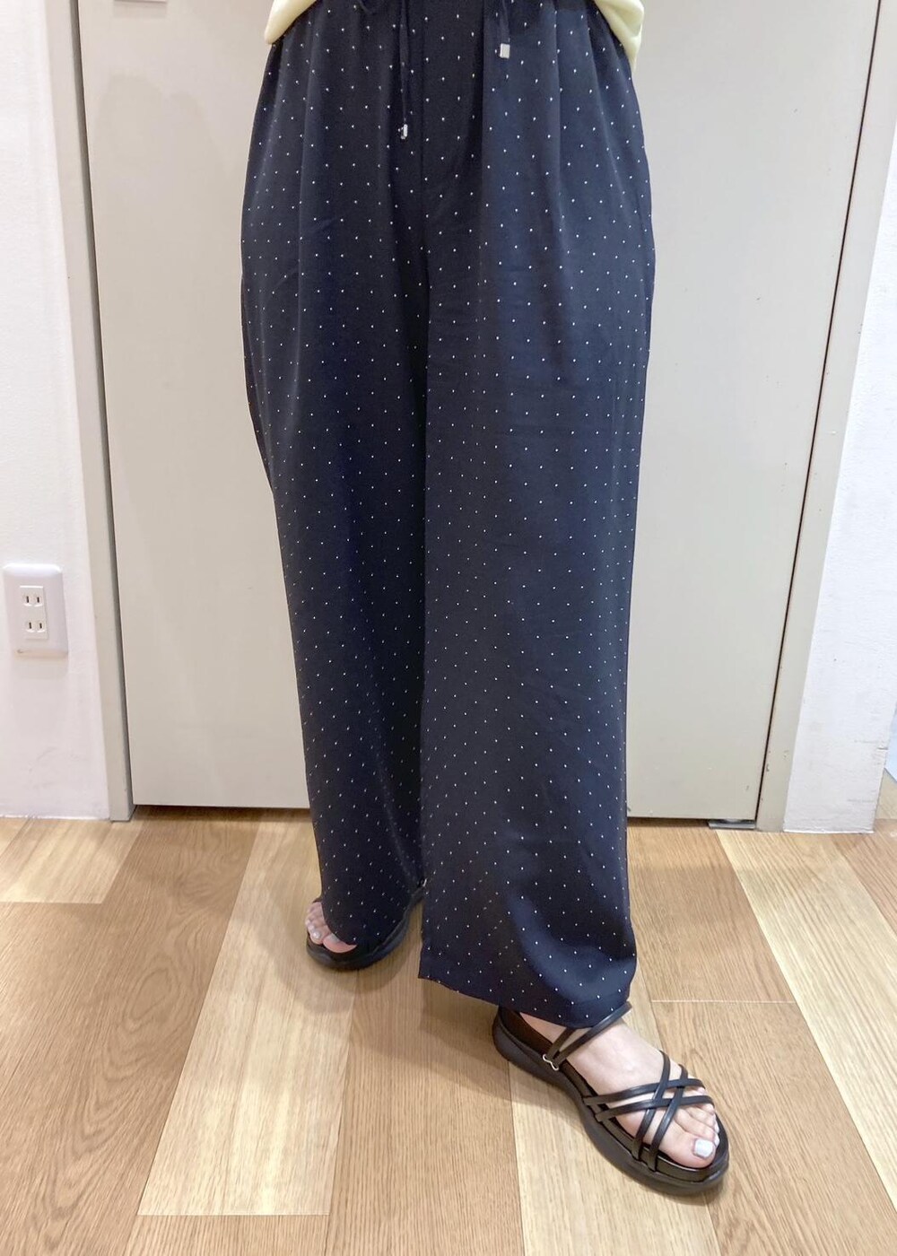 ベージュ系のタンクトップ、ホワイト系のTシャツ/カットソー、ブラック系のサンダルを着用したレディースの夏コーディネートの5枚目の写真