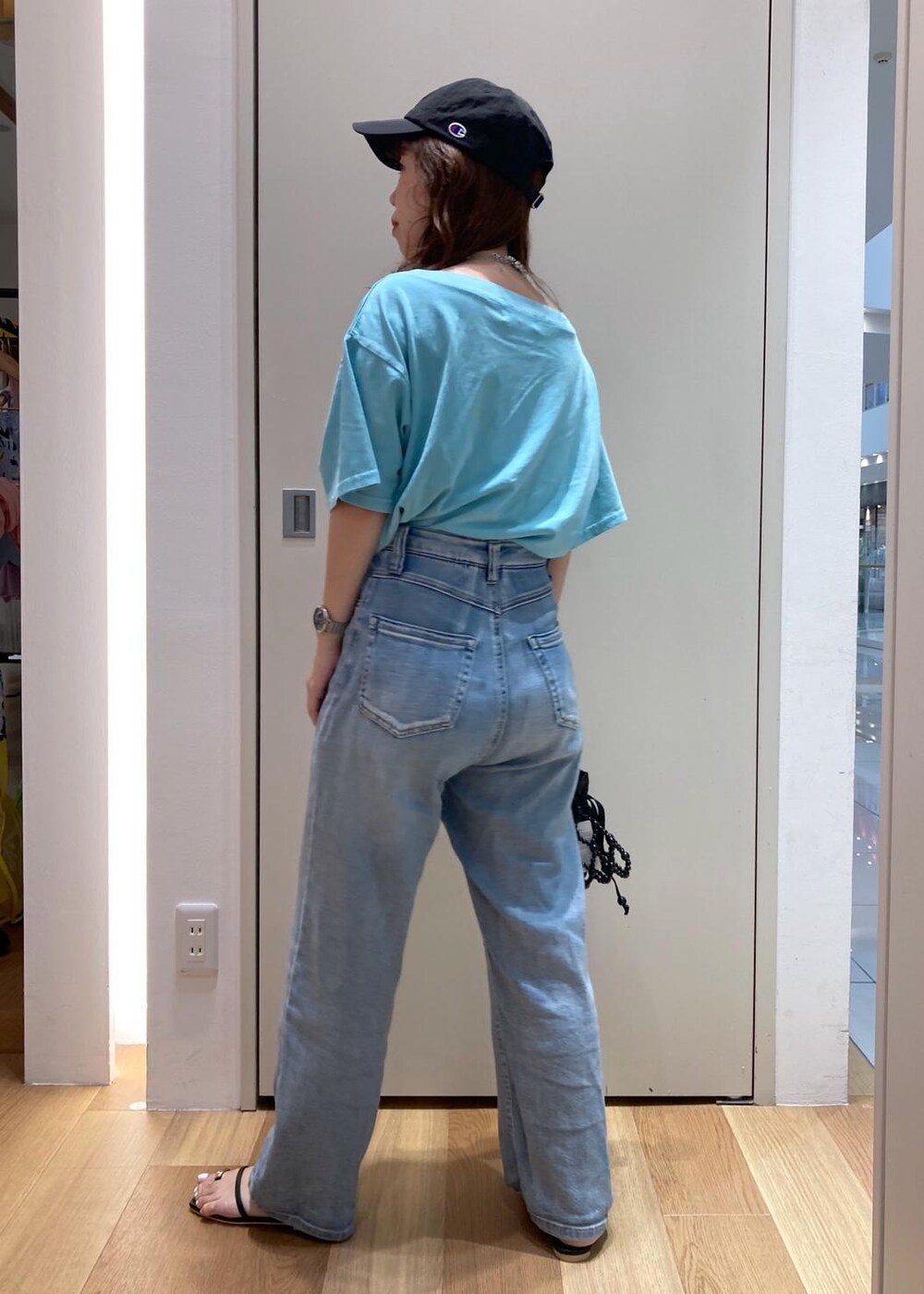 ブラック系のサンダル、ブラック系のハンドバッグ、ブルー系のTシャツ/カットソーを着用したレディースの夏コーディネートの3枚目の写真