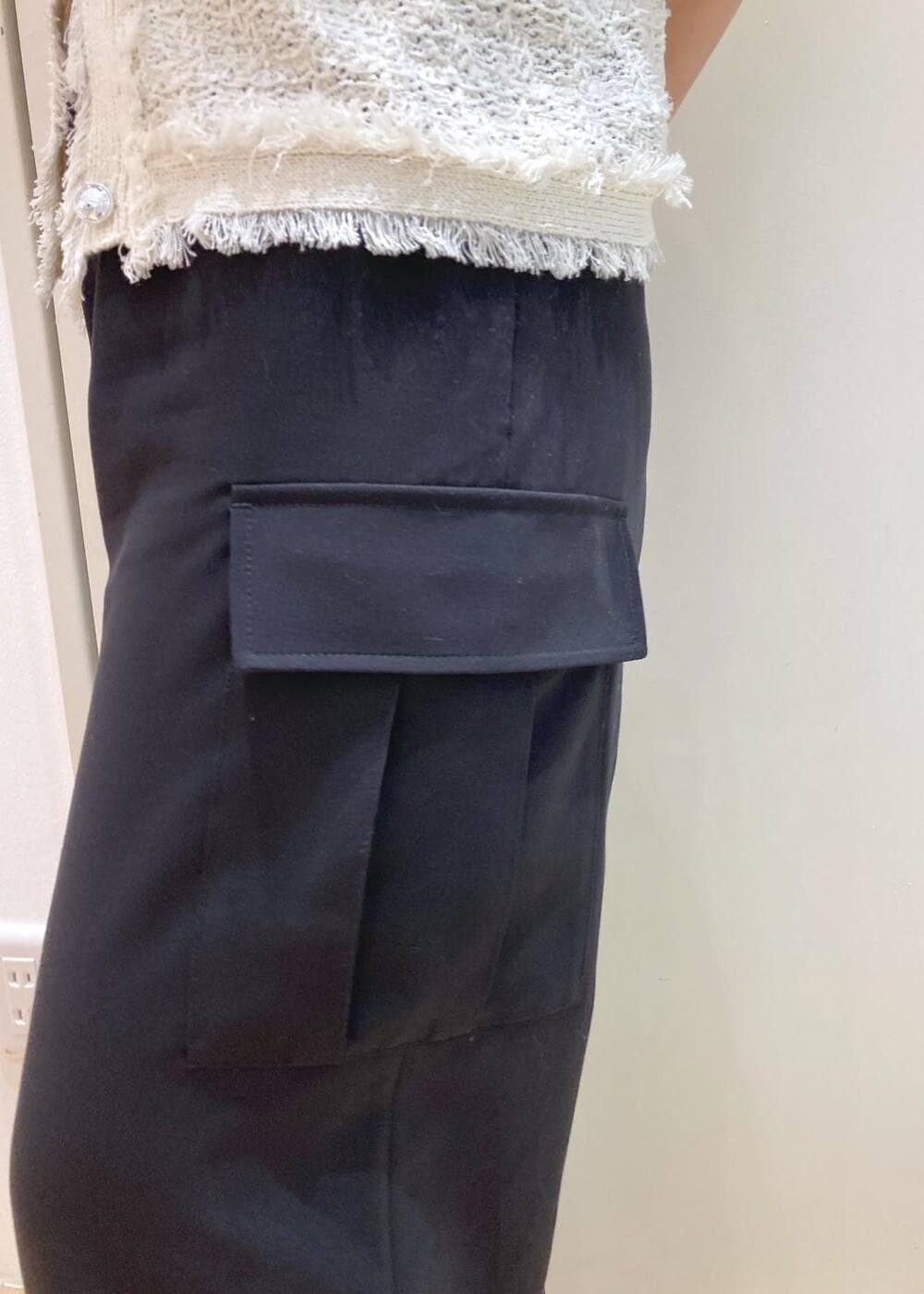 ピンク系のボストンバッグ、ブラック系のパンプス、ブラック系のカーゴパンツを着用したレディースの夏コーディネートの8枚目の写真