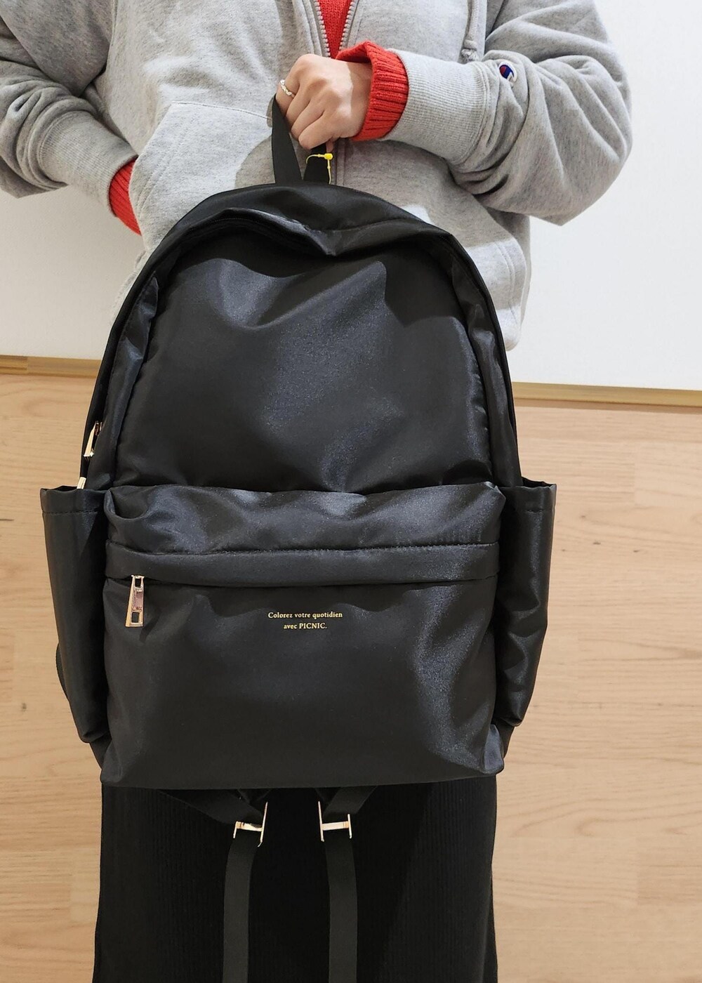 ブラック系のバックパック/リュック、レッド系のニット/セーター、ブラック系のその他パンツを着用したレディースの秋コーディネートの4枚目の写真