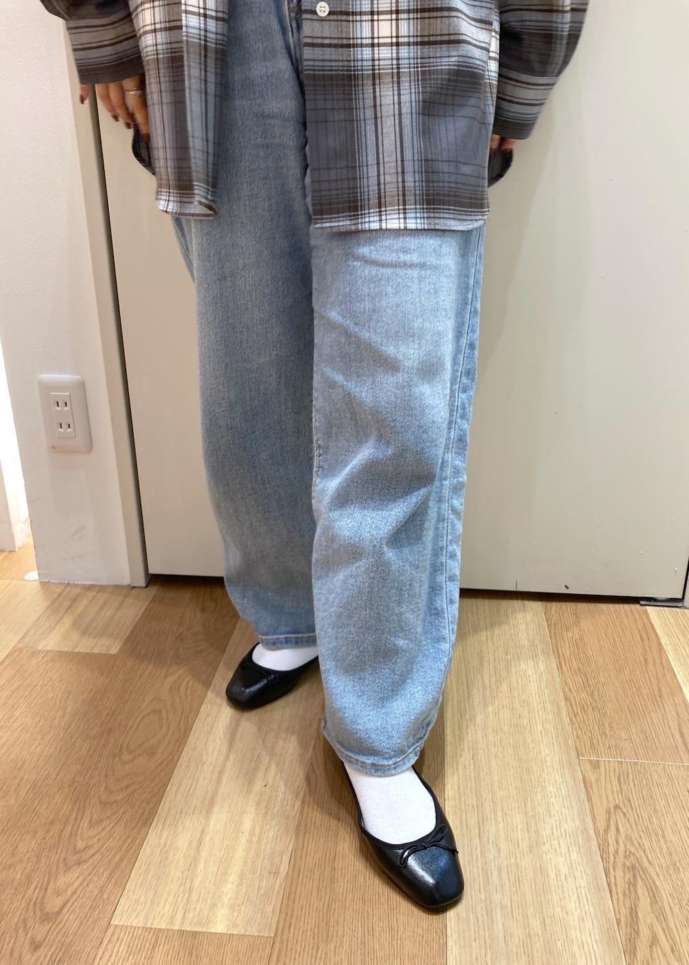 ブルー系のデニムパンツ、ブラック系のバレエシューズ、グレー系のシャツ/ブラウスを着用したレディースの秋コーディネートの6枚目の写真