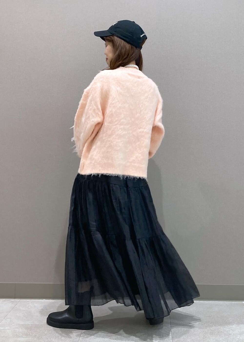 ブラック系のブーツ、ブラック系のトートバッグ、ピンク系のニット/セーターを着用したレディースの冬コーディネートの4枚目の写真