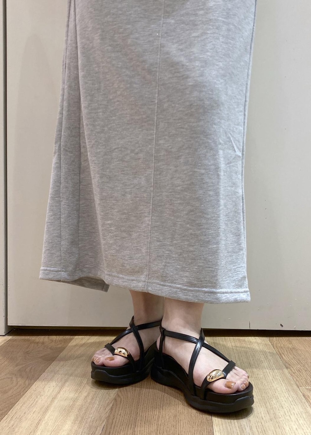 ブラック系のサンダル、グレー系のスカート、グレー系のTシャツ/カットソーを着用したレディースの夏コーディネートの9枚目の写真