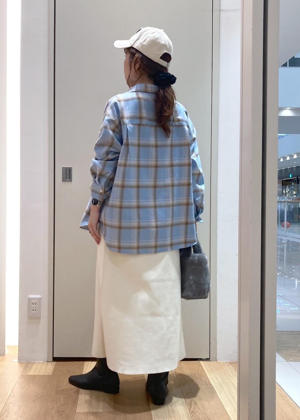 ホワイト系のスカート、ブルー系のシャツ/ブラウス、ブラック系のブーツを着用したレディースの秋コーディネートの3枚目の写真