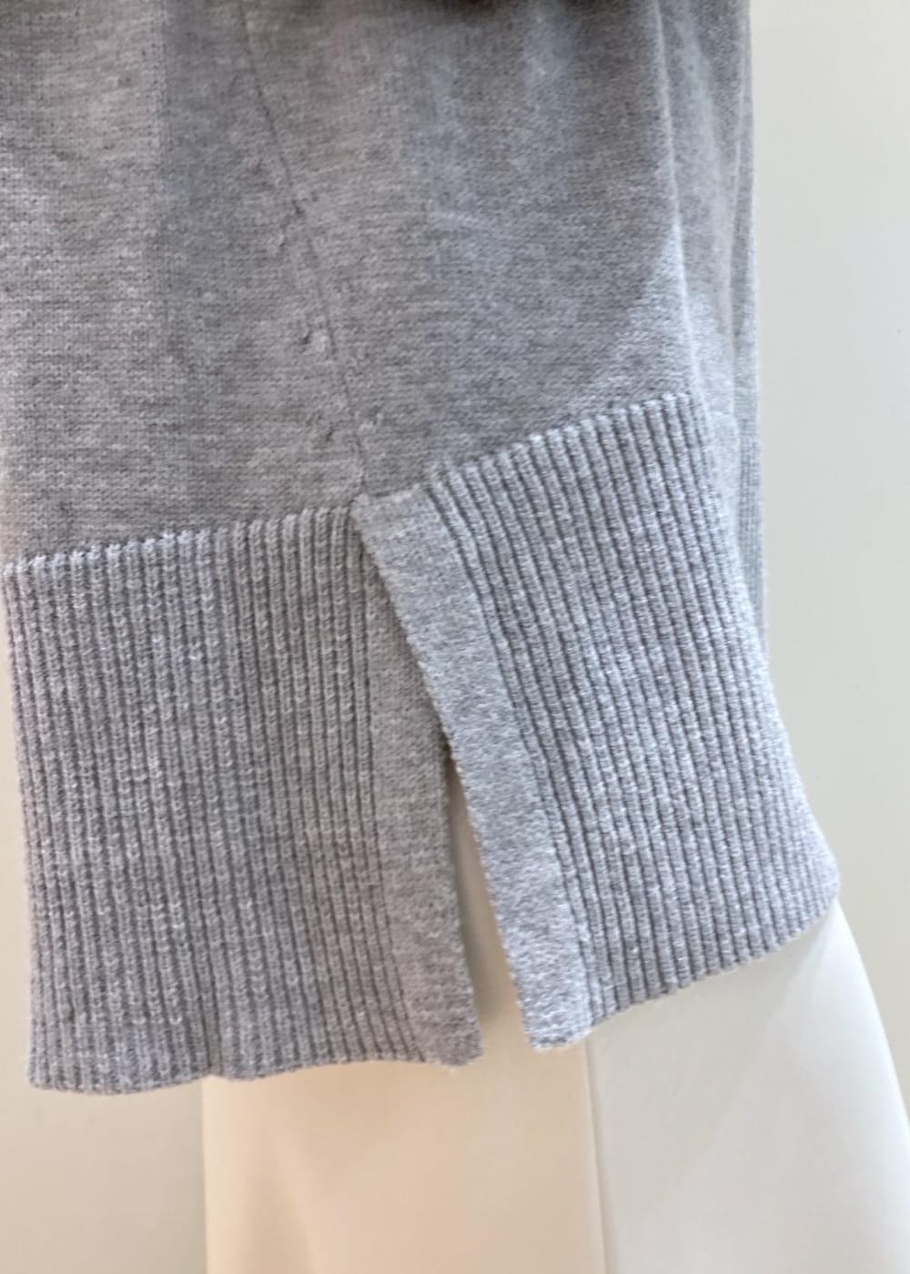 グレー系のニット/セーター、ホワイト系のスニーカー、ブラック系のショルダーバッグを着用したレディースの冬コーディネートの5枚目の写真