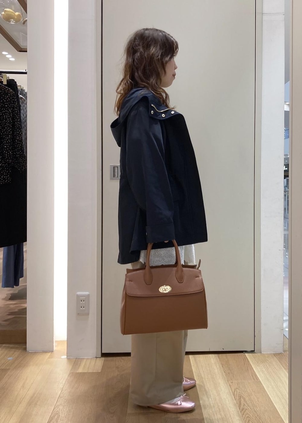 ベージュ系のチノパンツ、イエロー系のトートバッグ、ホワイト系のニット/セーターを着用したレディースの春コーディネートの2枚目の写真