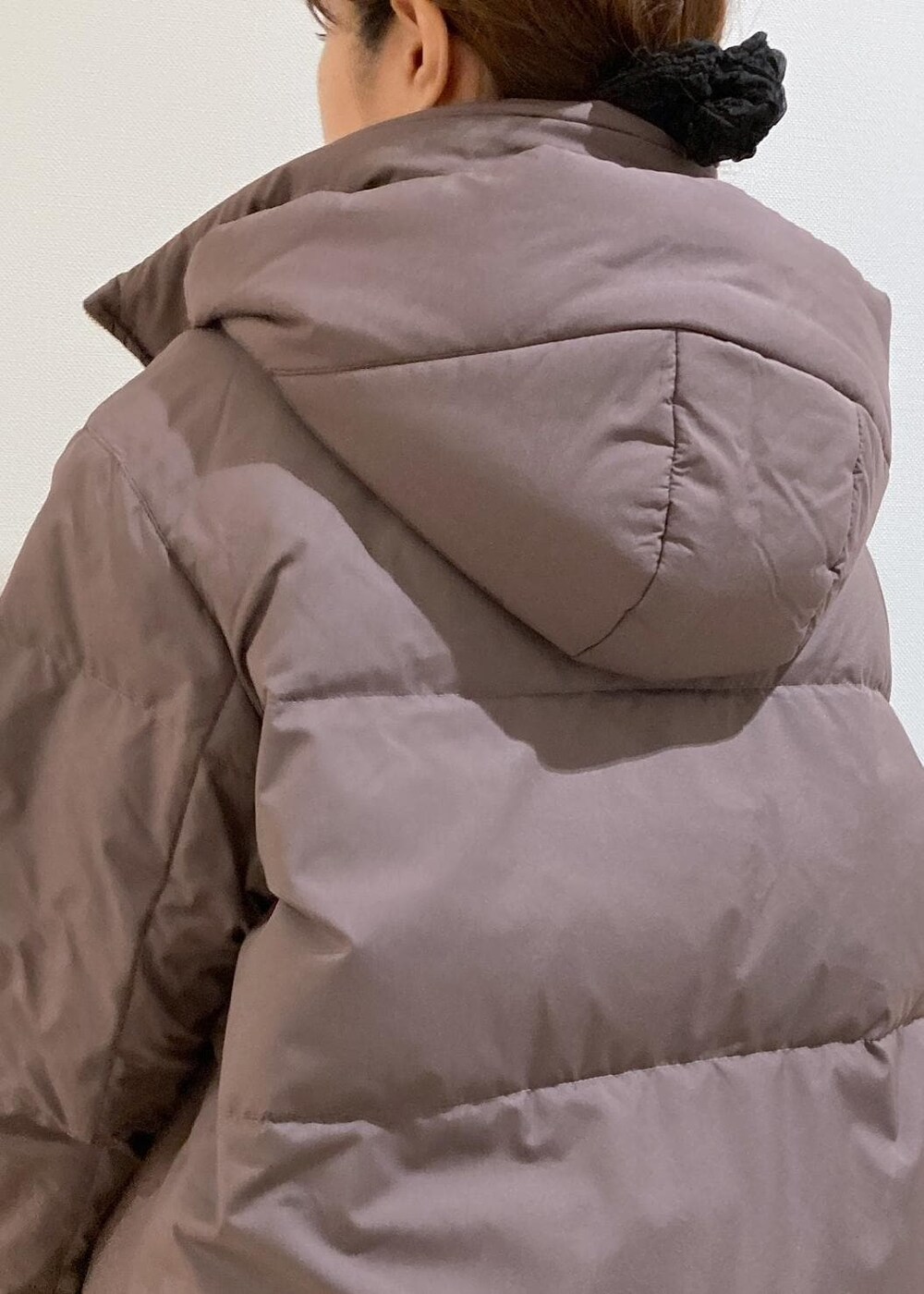 ブラウン系のダウンジャケット/コート、グレー系のニット/セーター、ブラック系のブーツを着用したレディースの冬コーディネートの4枚目の写真