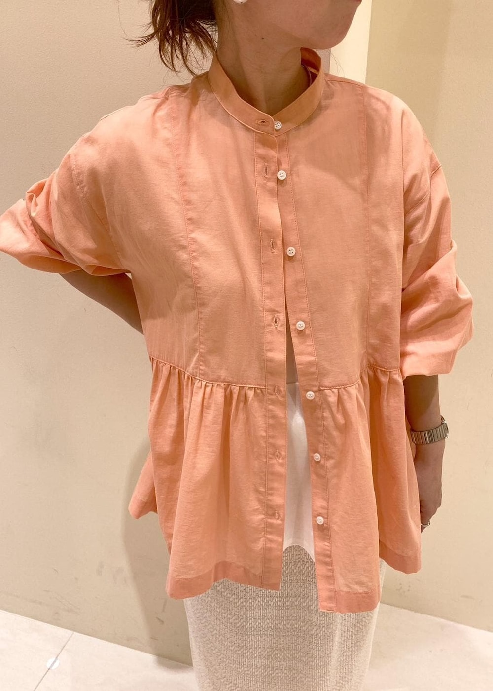 オレンジ系のシャツ/ブラウス、ベージュ系のショルダーバッグ、ホワイト系のTシャツ/カットソーを着用したレディースの春コーディネートの4枚目の写真