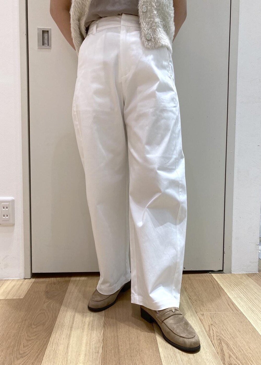 ベージュ系のトートバッグ、グリーン系のTシャツ/カットソー、ホワイト系のベストを着用したレディースの夏コーディネートの6枚目の写真