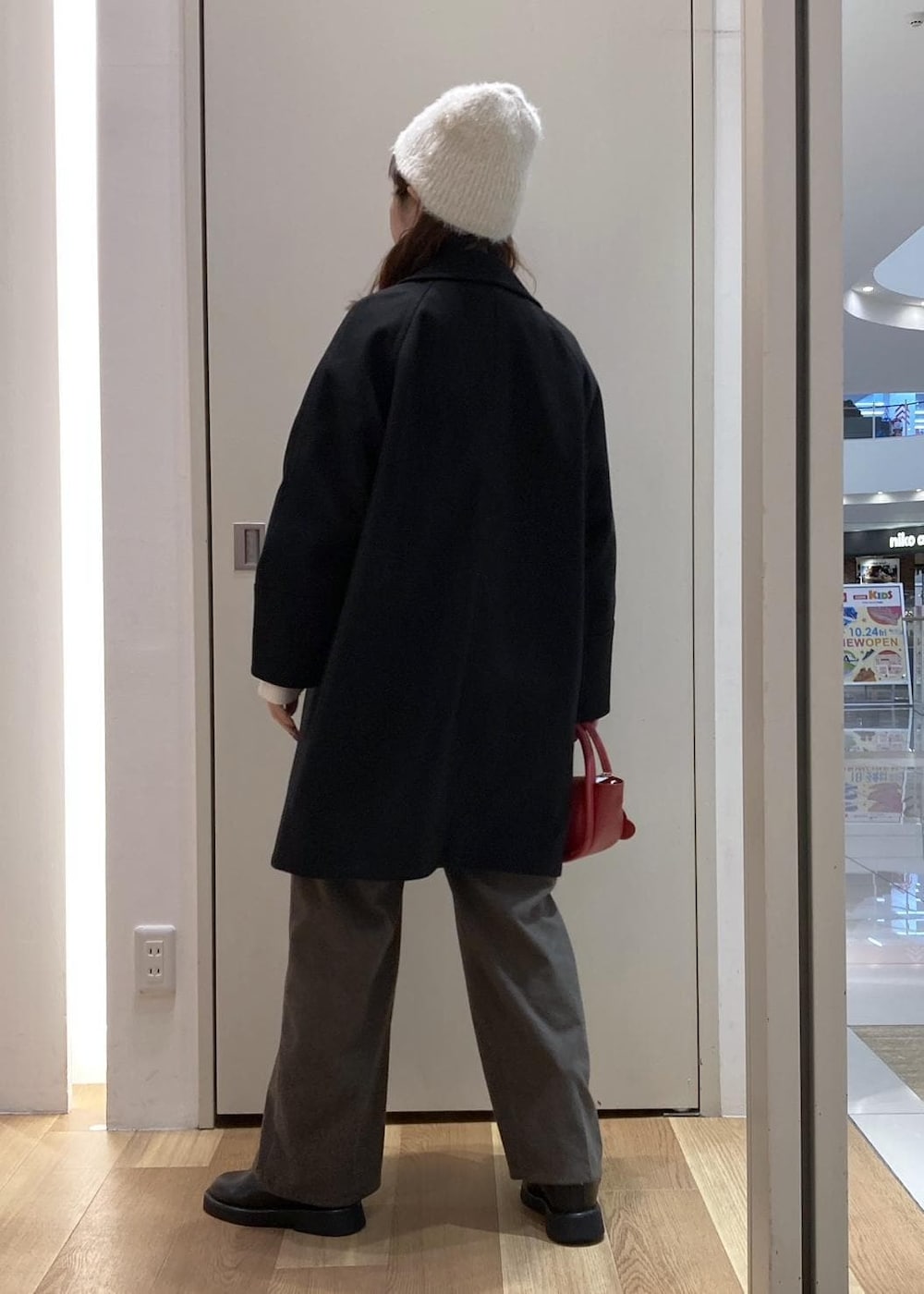 ホワイト系のニット/セーター、ブラウン系のその他パンツ、ブラック系のピーコートを着用したレディースの冬コーディネートの3枚目の写真