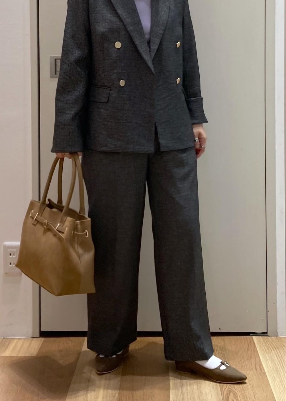 イエロー系のトートバッグ、パープル系のタンクトップ、グレー系のテーラードジャケットを着用したレディースの秋コーディネートの5枚目の写真