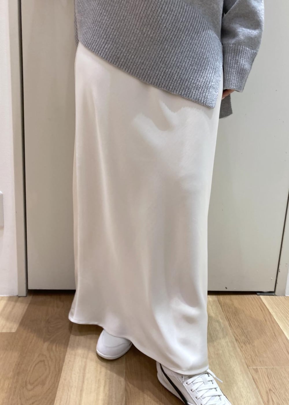 グレー系のニット/セーター、ホワイト系のスニーカー、ブラック系のショルダーバッグを着用したレディースの冬コーディネートの6枚目の写真