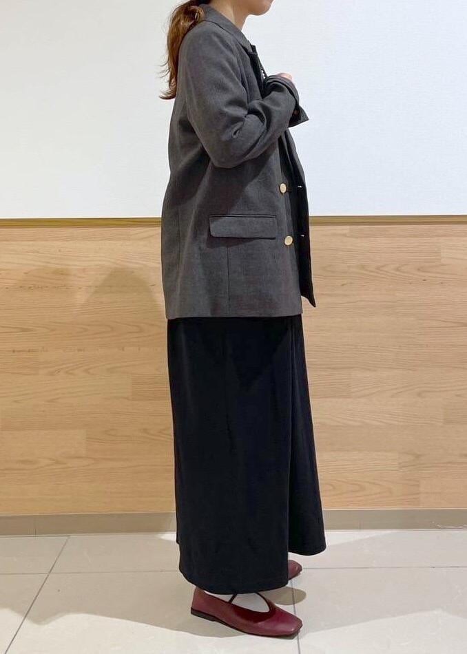 ブラウン系のテーラードジャケット、ブラック系のハンドバッグ、ブラック系のワンピースを着用したレディースの秋コーディネートの4枚目の写真