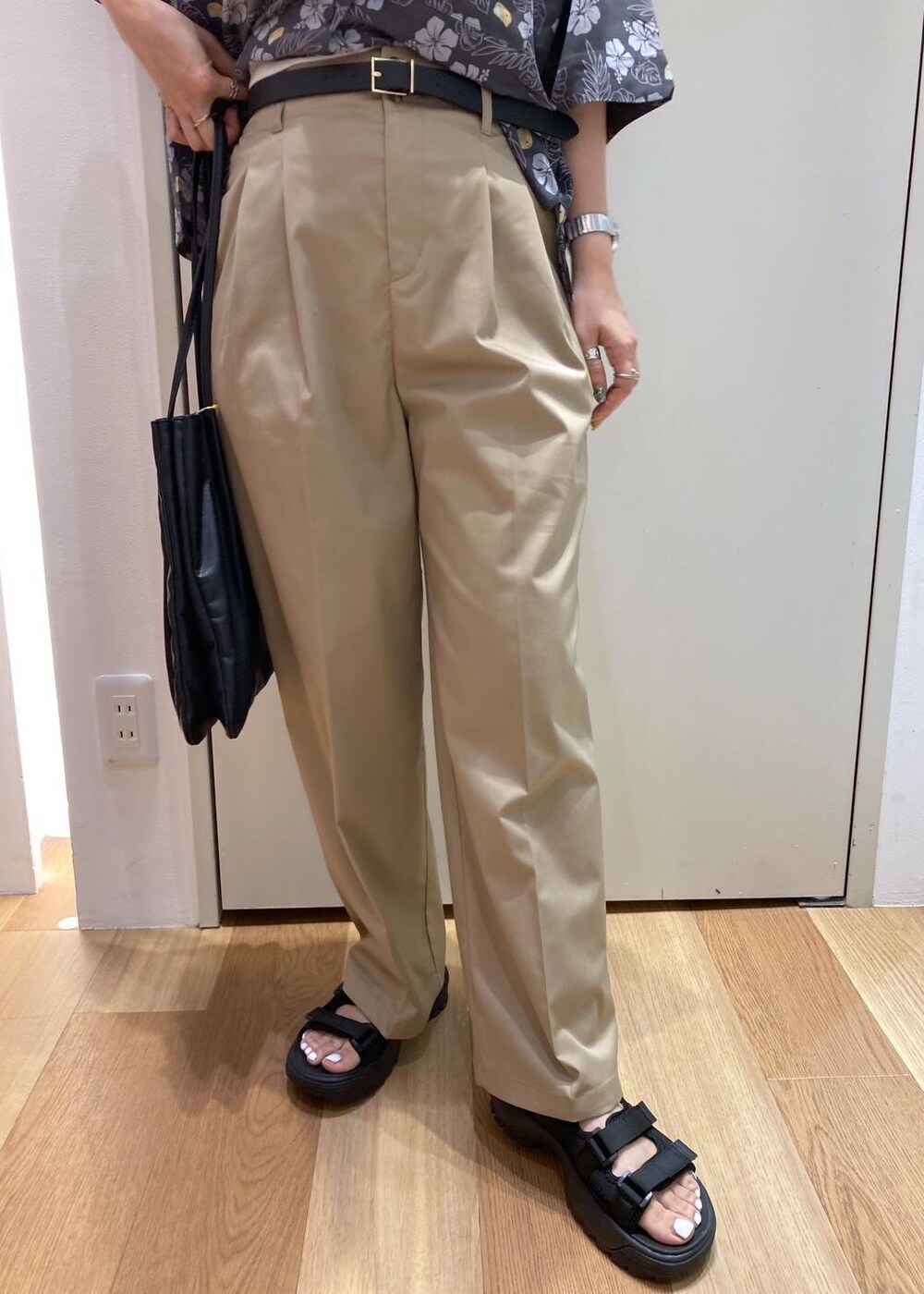 ブラック系のトートバッグ、ブラック系のサンダル、グレー系のチノパンツを着用したレディースの夏コーディネートの6枚目の写真