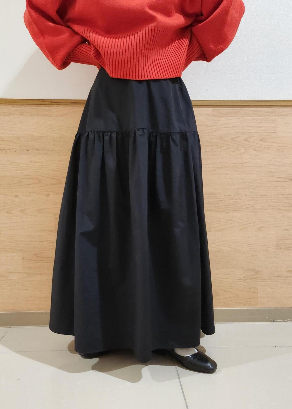 ブラック系のショルダーバッグ、レッド系のニット/セーター、ブラック系のスカートを着用したレディースの秋コーディネートの6枚目の写真