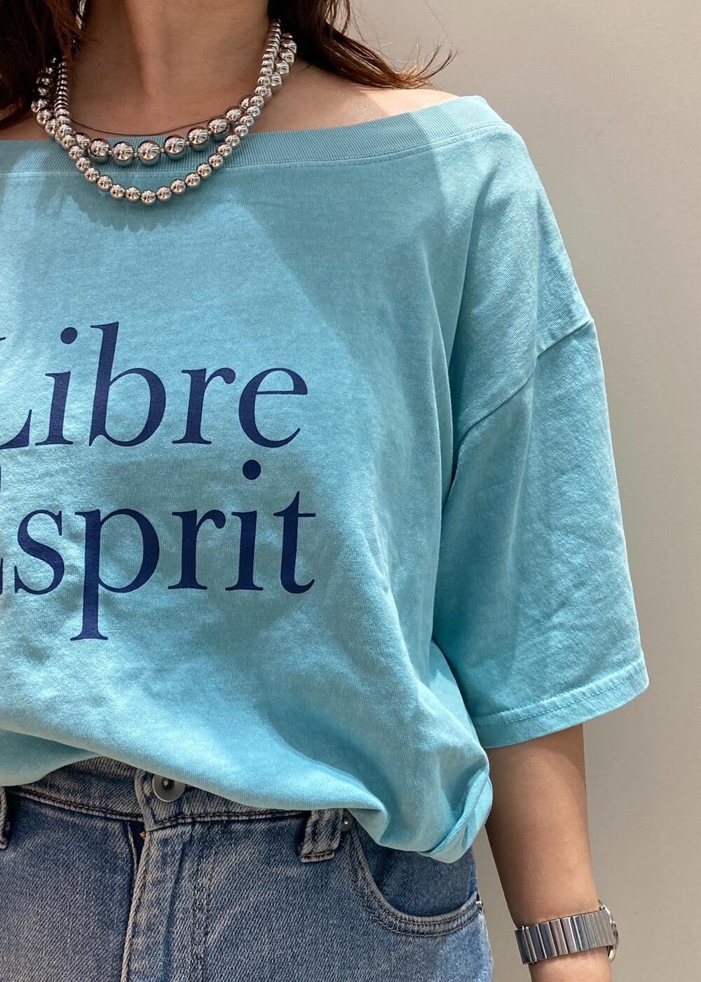 ブラック系のサンダル、ブラック系のハンドバッグ、ブルー系のTシャツ/カットソーを着用したレディースの夏コーディネートの5枚目の写真