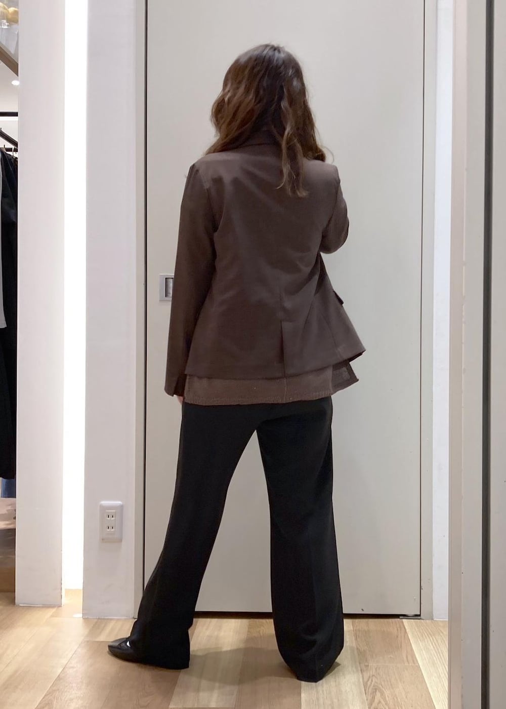 ブラック系のショルダーバッグ、イエロー系のニット/セーター、ブラウン系のテーラードジャケットを着用したレディースの春コーディネートの3枚目の写真