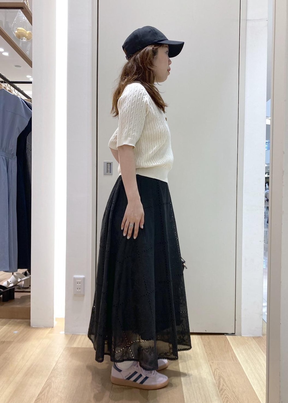 ブラック系のバックパック/リュック、ブラック系のスカート、ホワイト系のニット/セーターを着用したレディースの春コーディネートの2枚目の写真