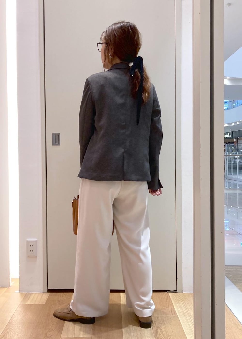 ブラウン系のトートバッグ、ホワイト系のその他パンツ、ブラウン系のテーラードジャケットを着用したレディースの秋コーディネートの3枚目の写真
