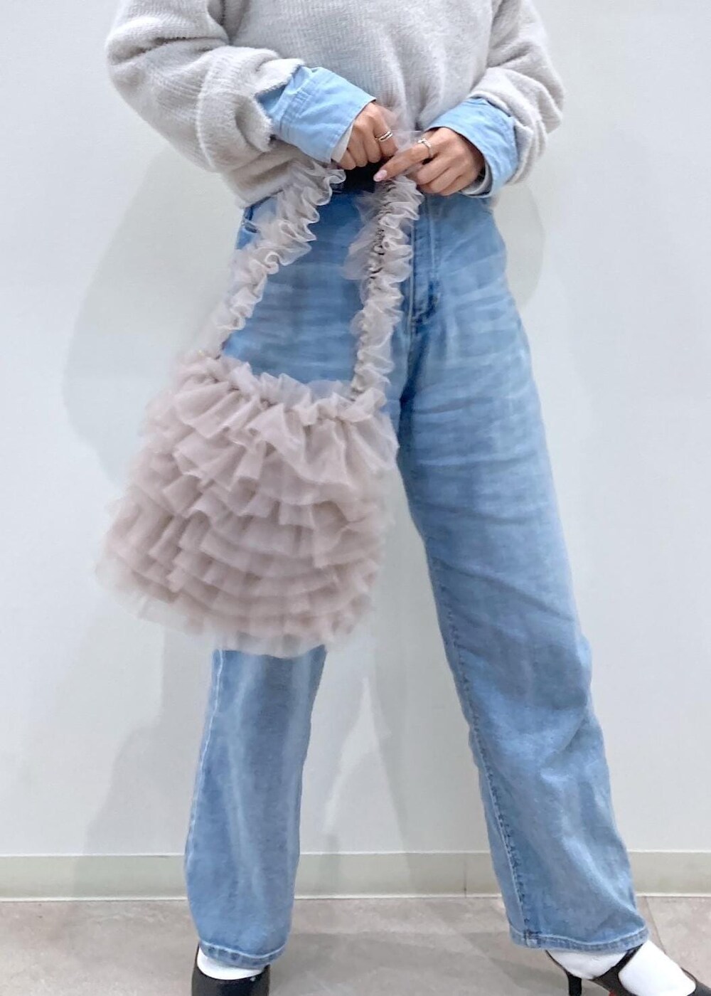 ブルー系のシャツ/ブラウス、ブラック系のパンプス、ブルー系のデニムパンツを着用したレディースの冬コーディネートの7枚目の写真