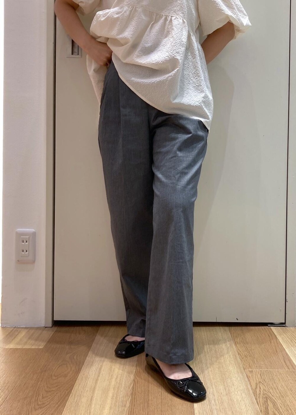 ブラック系のバレエシューズ、グレー系のチノパンツ、ホワイト系のシャツ/ブラウスを着用したレディースの夏コーディネートの7枚目の写真