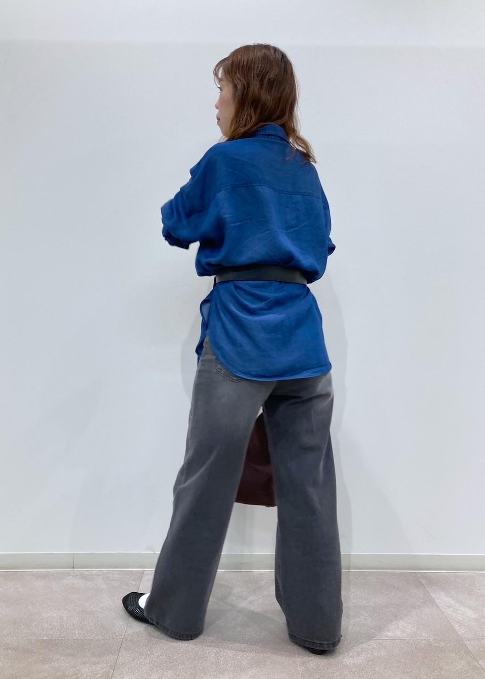 レッド系のショルダーバッグ、ブルー系のシャツ/ブラウス、ブラック系のデニムパンツを着用したレディースの夏コーディネートの3枚目の写真