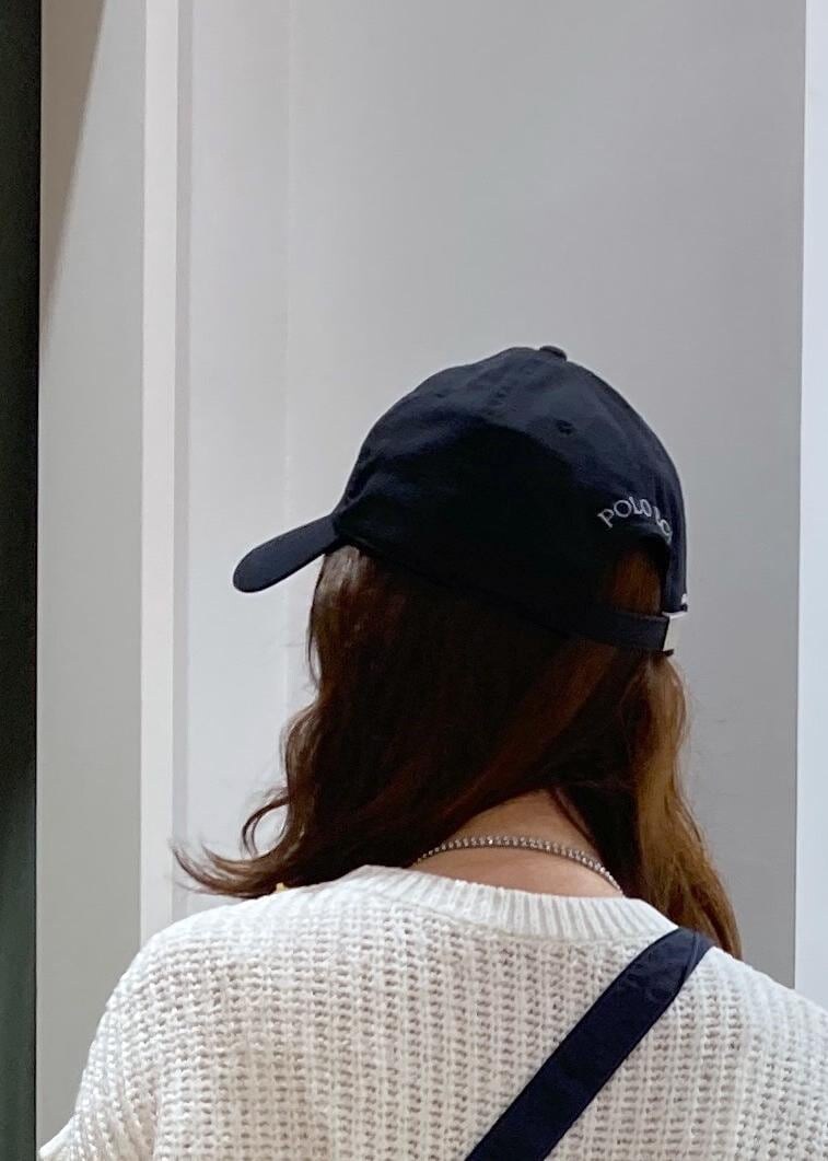 ホワイト系のワンピース、ブラック系のレインシューズ、ホワイト系のベストを着用したレディースの春コーディネートの9枚目の写真