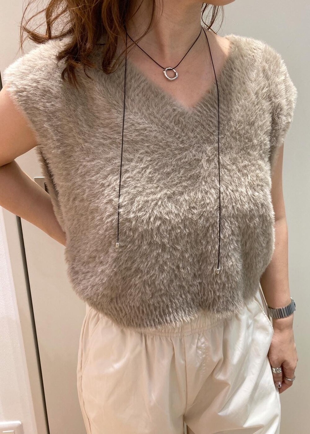 ベージュ系のローファー、ブラウン系のショルダーバッグ、ベージュ系のベストを着用したレディースの夏コーディネートの3枚目の写真