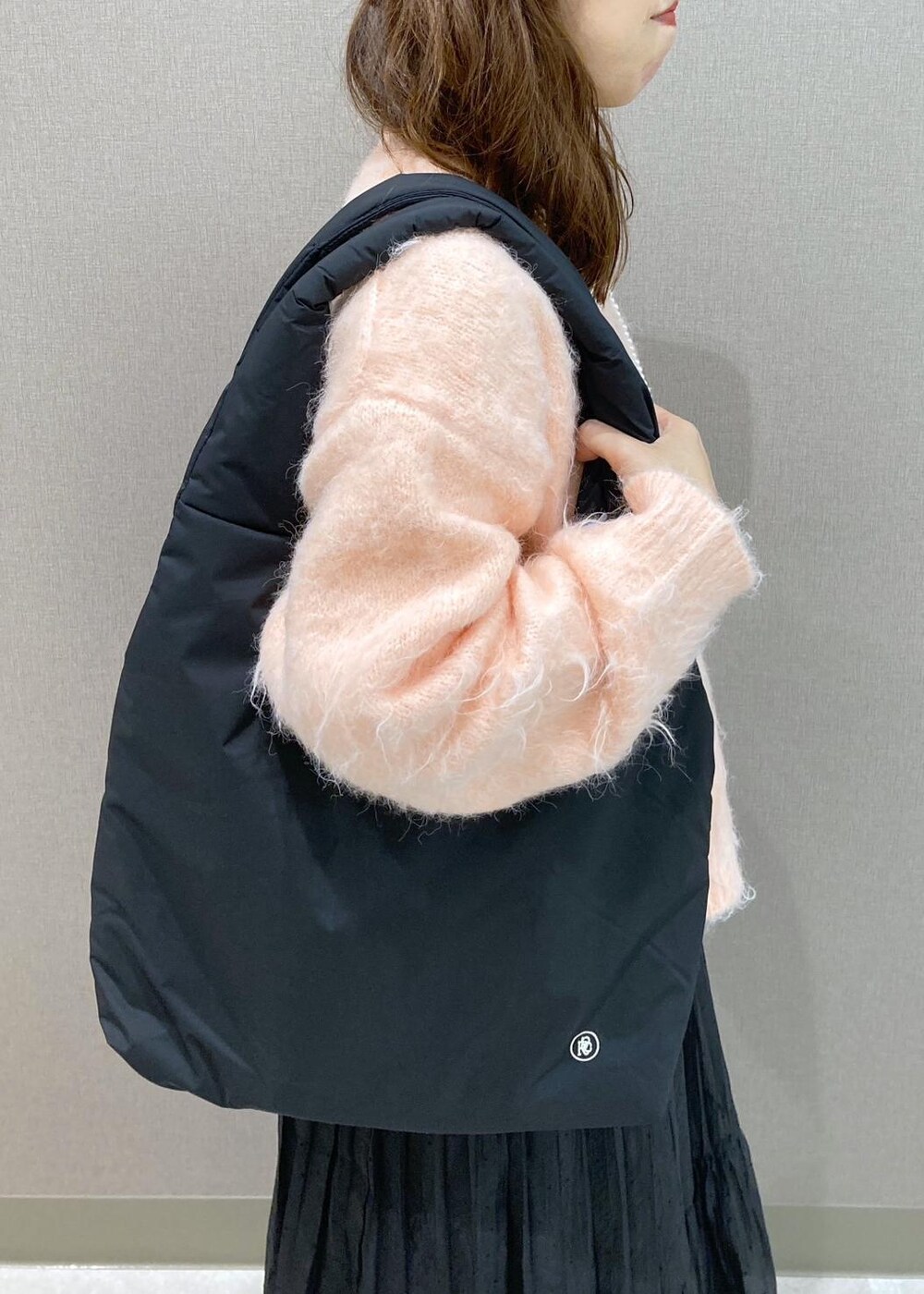 ブラック系のブーツ、ブラック系のトートバッグ、ピンク系のニット/セーターを着用したレディースの冬コーディネートの8枚目の写真