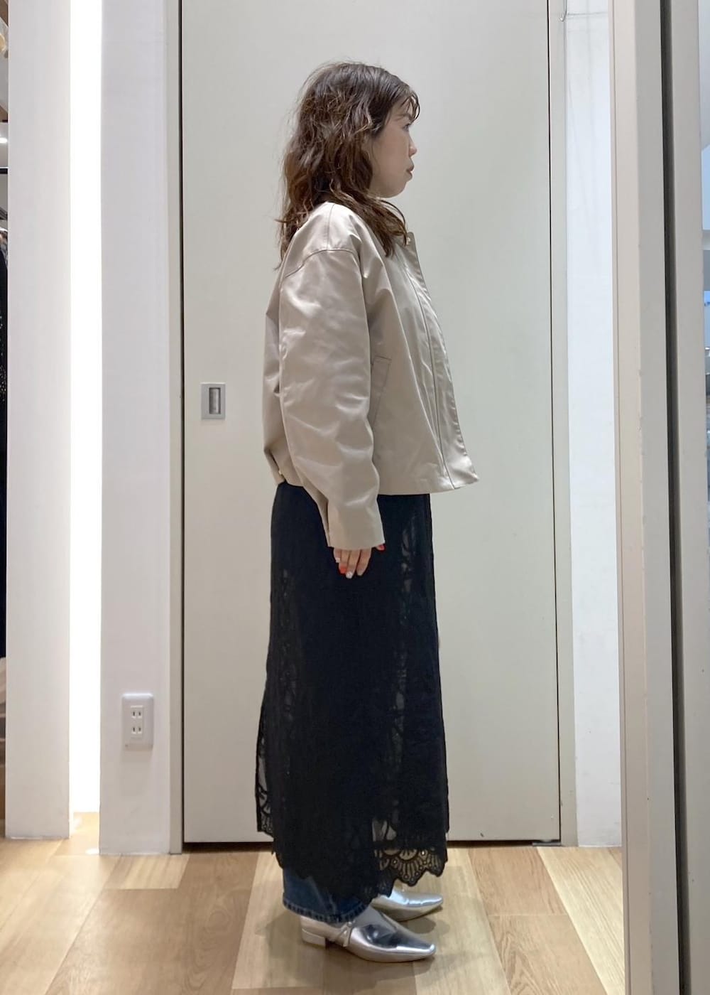 ホワイト系のボストンバッグ、ブルー系のデニムパンツ、ブラック系のワンピースを着用したレディースの春コーディネートの2枚目の写真