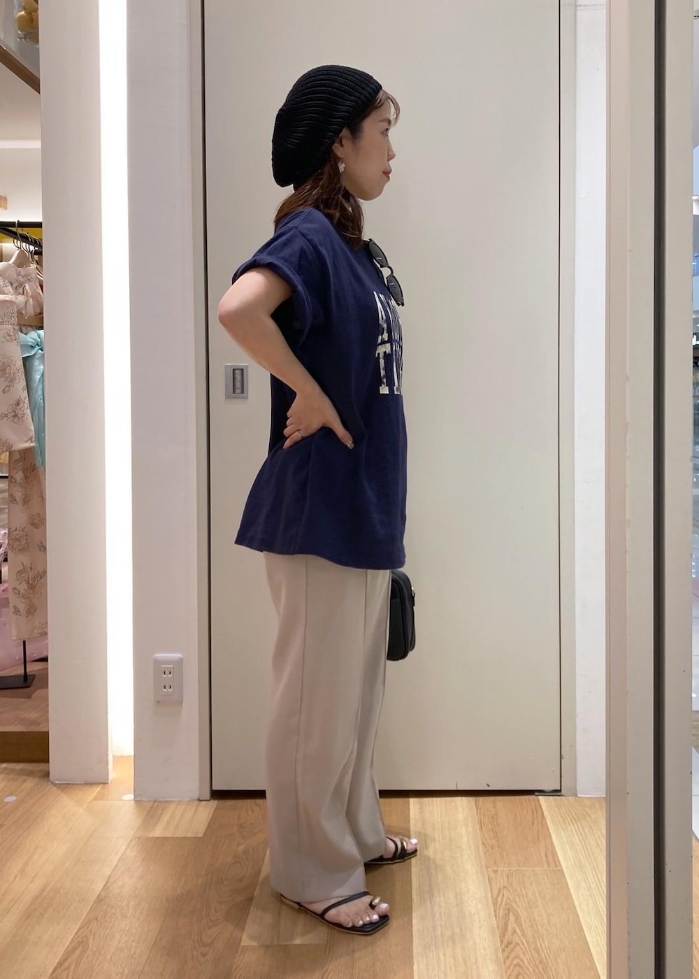 ベージュ系のその他パンツ、ブラック系のサンダル、ブラック系のショルダーバッグを着用したレディースの夏コーディネートの2枚目の写真