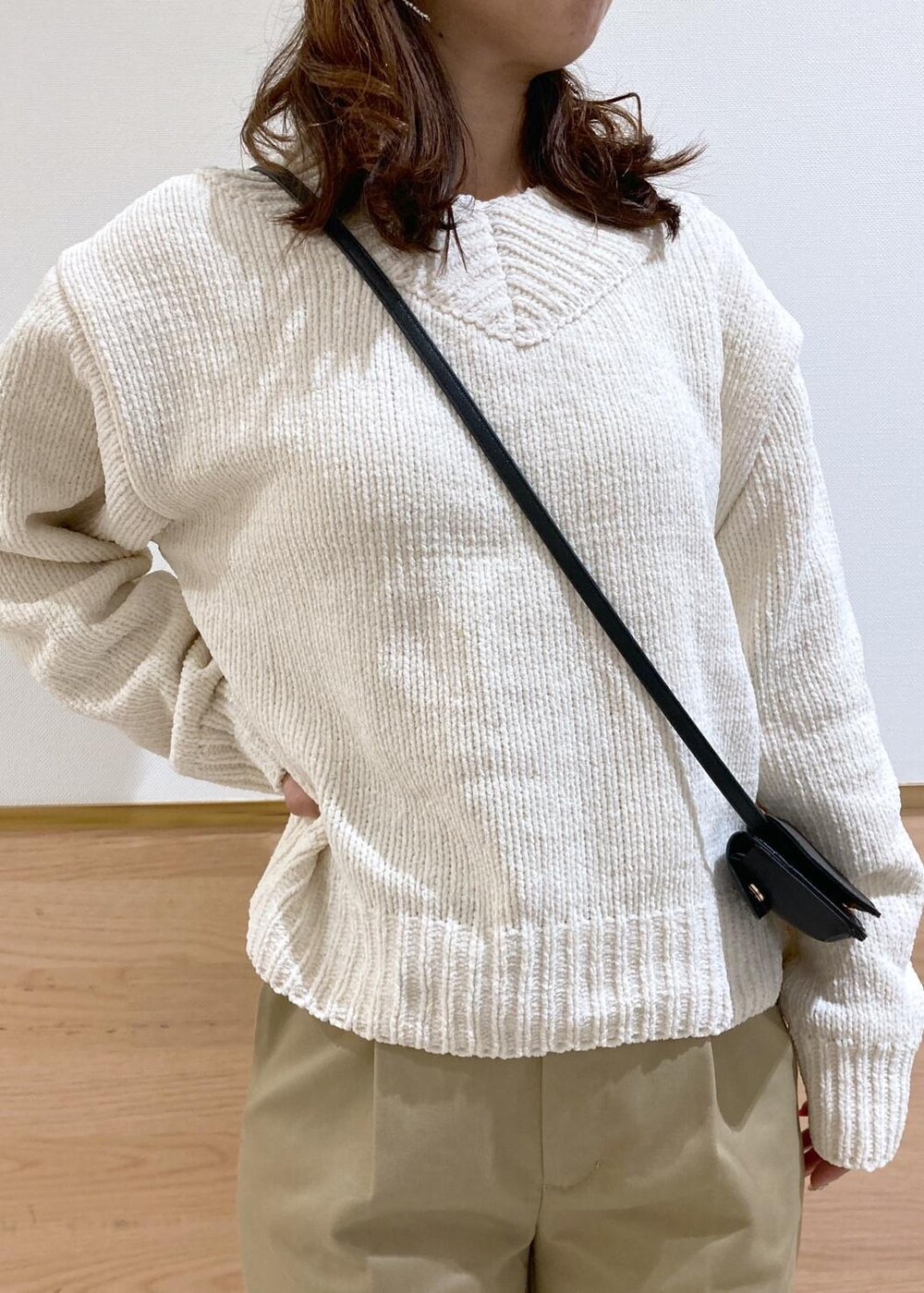 ホワイト系のニット/セーター、ブラック系のバレエシューズ、ベージュ系のチノパンツを着用したレディースの冬コーディネートの4枚目の写真