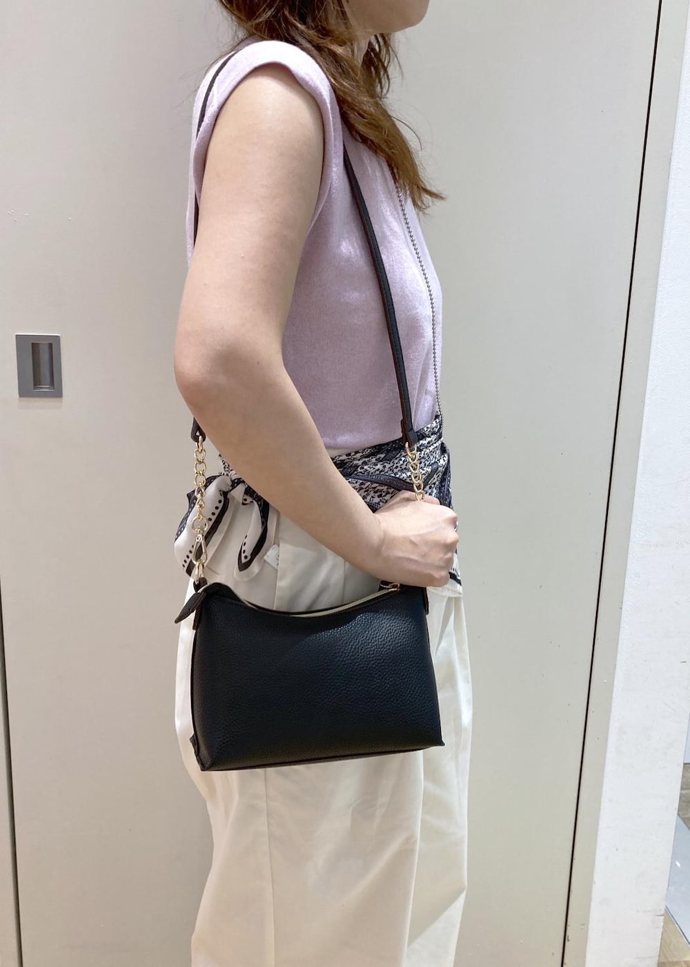 ホワイト系のチノパンツ、ブラック系のパンプス、ブラック系のショルダーバッグを着用したレディースの夏コーディネートの7枚目の写真