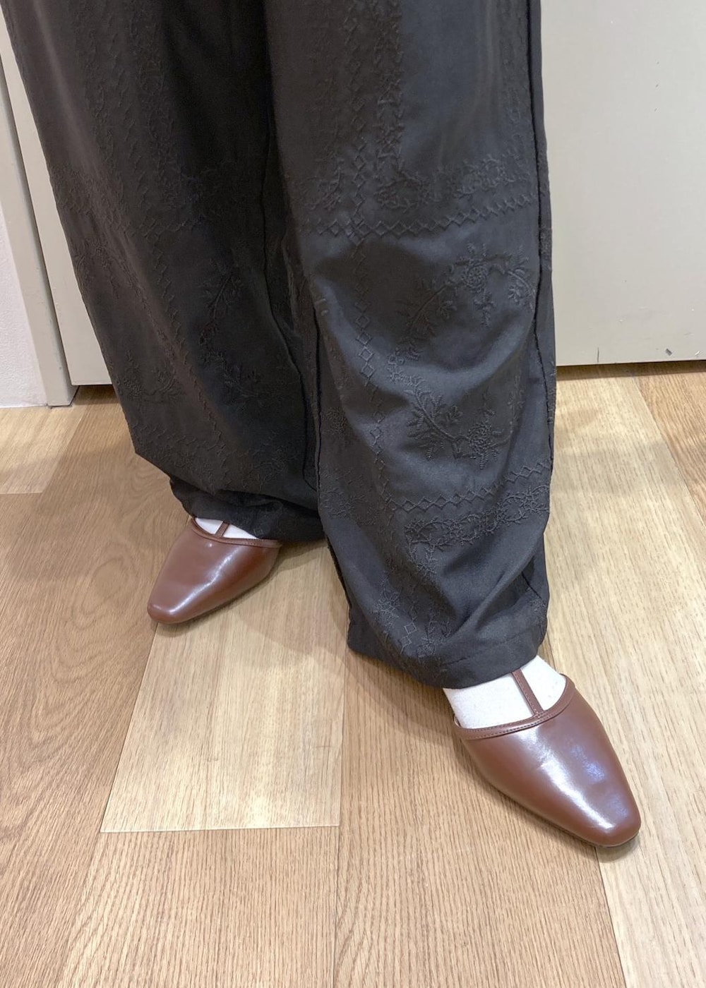 ブラウン系のボストンバッグ、ブラウン系のパンプス、ブラック系のシャツ/ブラウスを着用したレディースの春コーディネートの7枚目の写真