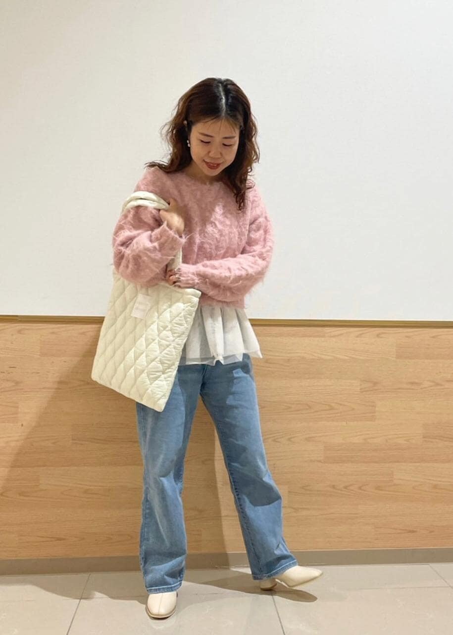 ホワイト系のブーツ、ホワイト系のトートバッグ、ブルー系のデニムパンツを着用したレディースの冬コーディネートの2枚目の写真