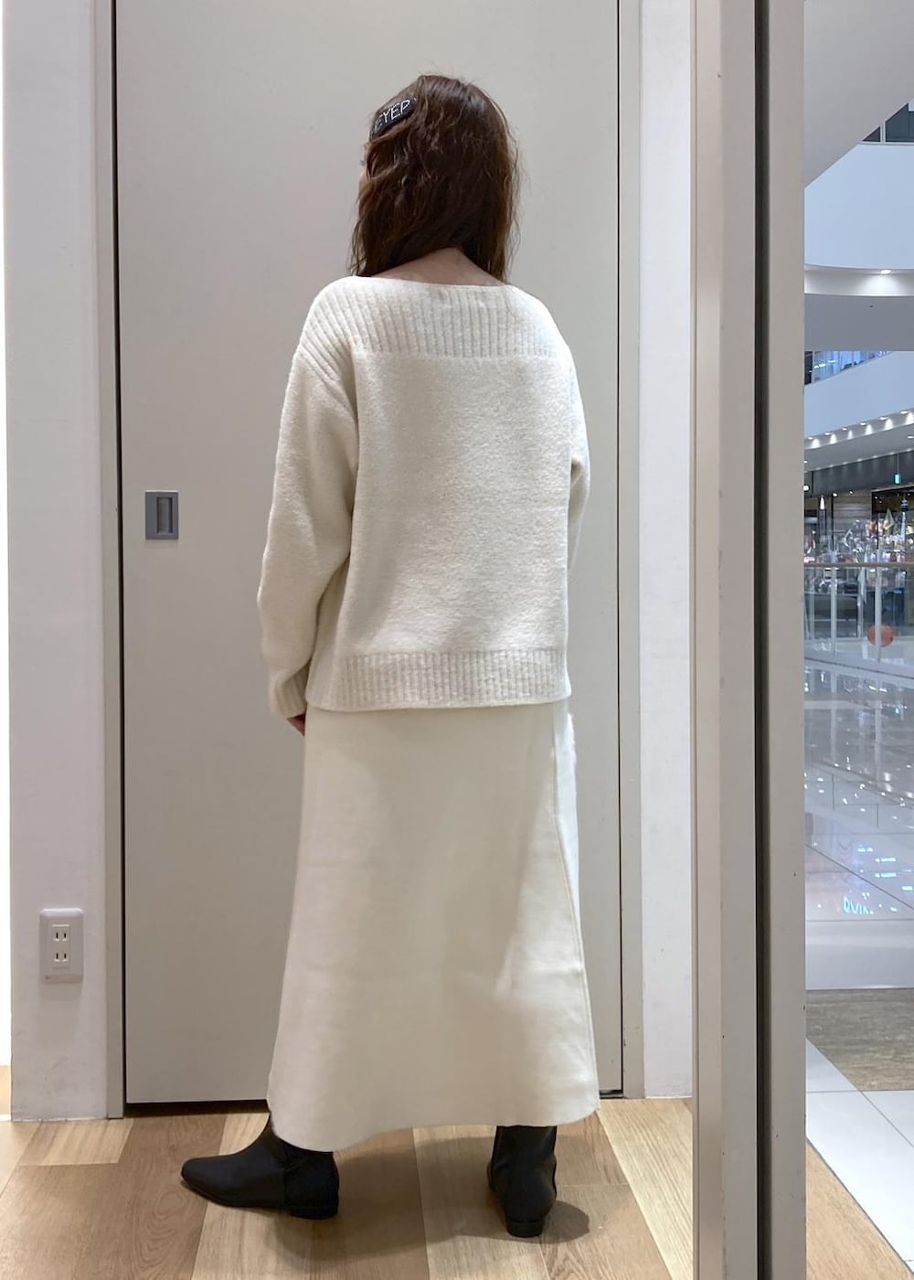 ホワイト系のニット/セーター、ブラック系のブーツ、ホワイト系のスカートを着用したレディースの秋コーディネートの3枚目の写真