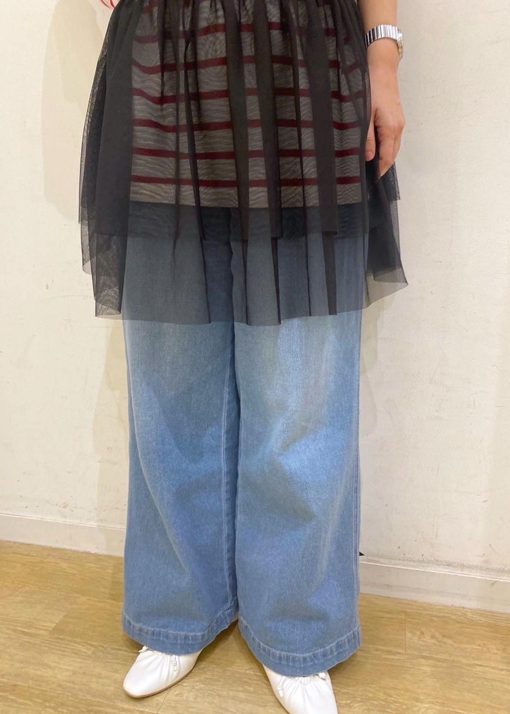 ブラック系のベスト、レッド系のTシャツ/カットソー、ホワイト系のパンプスを着用したレディースの春コーディネートの6枚目の写真